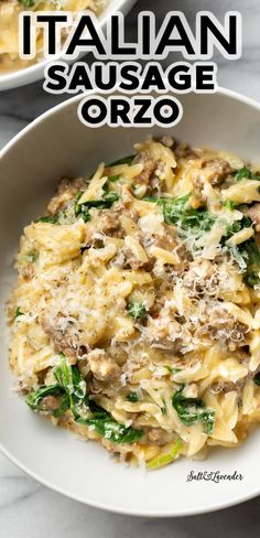 pasta with sausage and spinach in a white bowl on a marble countertop next to another dish