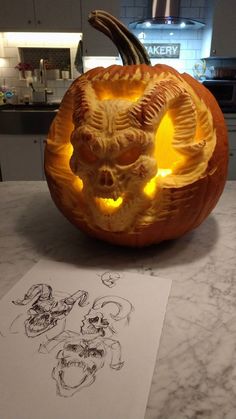 a carved pumpkin with an image of a demon on it and another drawing in the background