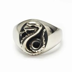 a silver ring with a black and white snake on it