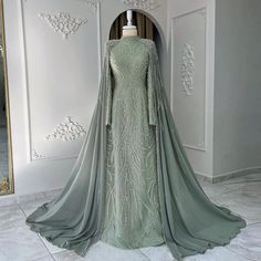 Experience the elegance and grace of our Dreamy Vow Luxury Evening Dress. With intricate beaded detailing, a stunning sage green color and a flowing cape, this dress is perfect for Muslim women seeking a luxurious and modest look. Complete with long sleeves, the perfect choice for any Arabic Dubai wedding or party. Custom Flower Girl Dress, Yellow Evening Dresses, Silver Evening Dress, Purple Evening Dress, Champagne Evening Dress, Muslim Evening Dresses, Green Evening Dress, Sage Green Dress, Girls Long Dresses