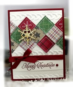 a christmas card with a snowflake on the front and red ribbon around it