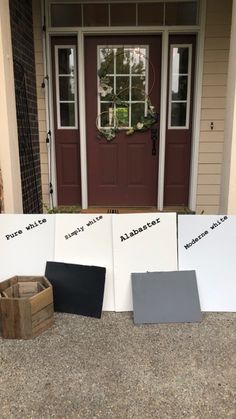 three different colors of paint sitting on the ground in front of a door with two boxes