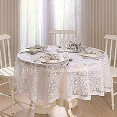 the table is set for two with white chairs and plates on it, along with silverware