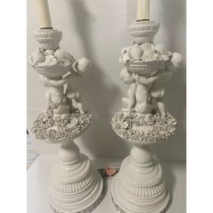 two white candlesticks sitting next to each other