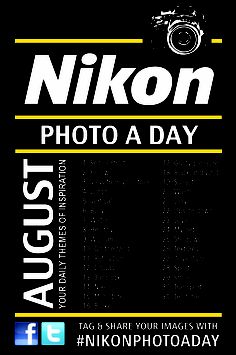 a black and yellow poster with the words nikon photo a day written below it