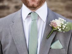 a man wearing a suit and tie with a boutonniere on his lapel