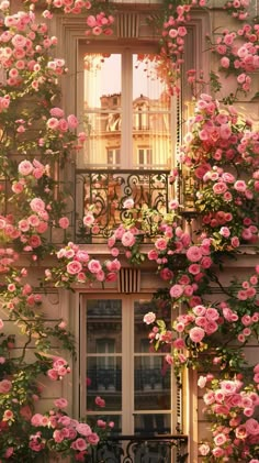 pink flowers are growing on the side of a building with balcony railings and windows