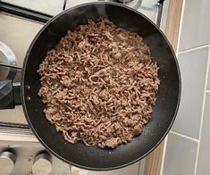 a frying pan filled with meat on top of a stove