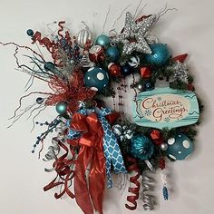 a christmas wreath hanging on the wall next to a sign that says christmas greetings