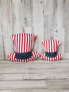 two red, white and blue patriotic hats sitting on top of a wooden table next to each other