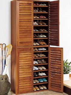 a wooden cabinet with several pairs of shoes on it and an umbrella next to it