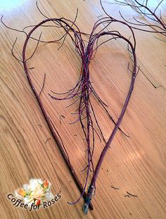 a heart - shaped piece of wire is on the floor next to a flower vase