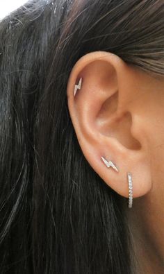 a close up of a person's ear with an arrow shaped piercing on it