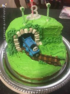 a thomas the tank engine birthday cake with candles on top and green frosted icing