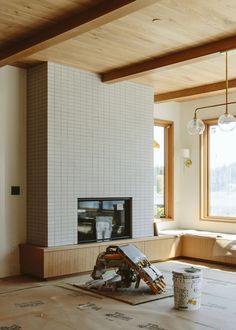 a living room that is being remodeled with wood flooring and white tiles on the walls