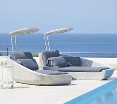 an outdoor lounge area next to a swimming pool