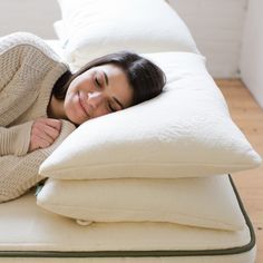 a woman laying on top of a white pillow