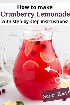 a pitcher filled with cranberry lemonade and garnished with orange slices