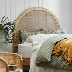 a bedroom with wicker headboard and green bedding