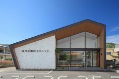 an empty parking lot in front of a white brick building with japanese writing on it