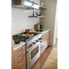 a stove top oven sitting inside of a kitchen next to wooden cabinets and counter tops