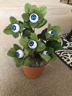 a potted plant with fake eyeballs on it's eyes and green leaves