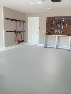 an empty garage is shown with tools on the wall and pegs hanging from the ceiling