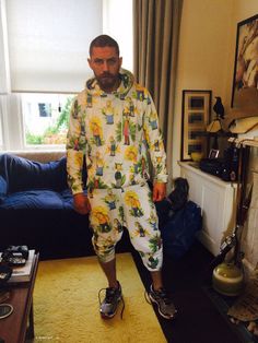 a man standing in his living room wearing an unisex pajama set