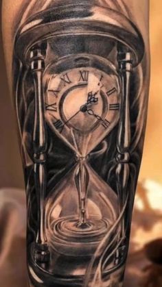 a tattoo with an hourglass on the leg and a clock in the middle of it