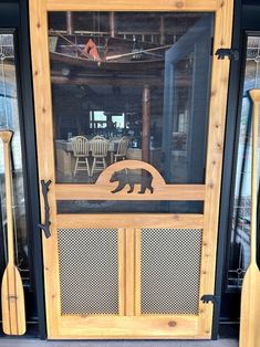 a wooden door with a carved bear on the front and side panels, as well as two paddles