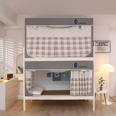 the bunk bed is made up with two sets of mattresses and curtains on it