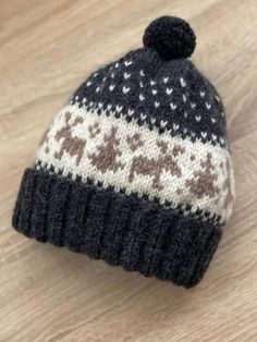 a knitted hat sitting on top of a wooden table