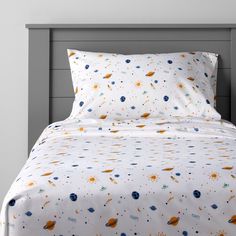 an image of a bed with space themed sheets and pillowcases on top of it