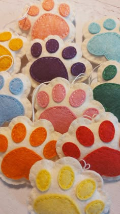 several different colored dog paw ornaments on a table