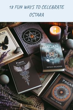 a bunch of books sitting on top of a table next to candles and some flowers