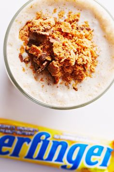 a cereal bar next to a glass filled with milkshake and oatmeal