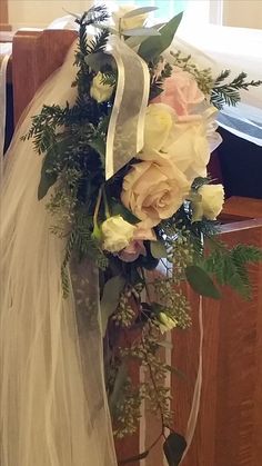 a bouquet of flowers sitting on top of a church pew