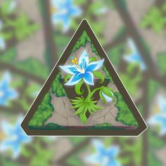 a blue flower sitting in the middle of a triangle shaped object with green leaves on it