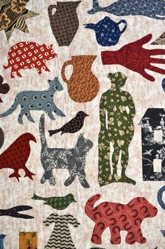 a quilted wall hanging with various animal designs on it's sides and an image of a man holding a watering can