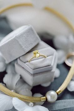 an engagement ring sitting on top of a white box next to a necklace and bracelet