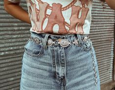 Simple silver belts are all the rage this season! Which means adding our Silver Concho Belt to your closet is a must. Wear with your favorite denim to make a statement all while showing off your western flair!   S/M is 42in end to end, but you can adjust the last 7-8in (Pendant 16pcs) L/XL is 45.5in end to end, but you can adjust the last 7-8in (Pendant 18pcs)  Model is wearing S/M. Silver Western Belt, Concho Belt Outfit, Western Belts Outfit, Country Belts, Belt Outfit, Cowgirl Aesthetic, Rodeo Outfits, Concho Belt, Western Belt