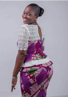 a woman in a purple and white dress with her hand on her hip, smiling at the camera