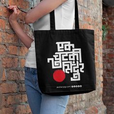 a woman is leaning against a brick wall with a tote bag on her shoulder