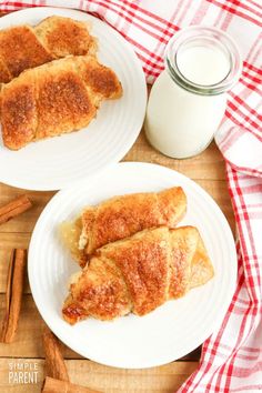 two white plates topped with pastries next to a jar of milk and cinnamon sticks