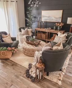 a living room filled with lots of furniture and decor on top of a hard wood floor