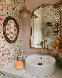 a white sink sitting under a bathroom mirror next to a wall mounted faucet