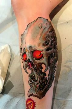 a person with a skull tattoo on their leg and one eye is red in the center