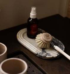 a cup and brush sitting on top of a tray