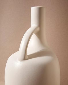 a white vase sitting on top of a table