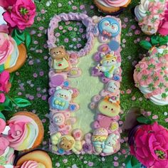 there are many cupcakes and cakes on the grass with flowers around them,